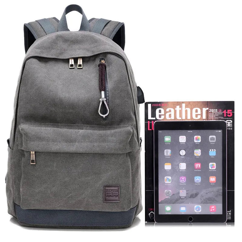 Canvas backpack with USB charging port shown in grey, featuring a laptop sleeve and front zipper pocket.