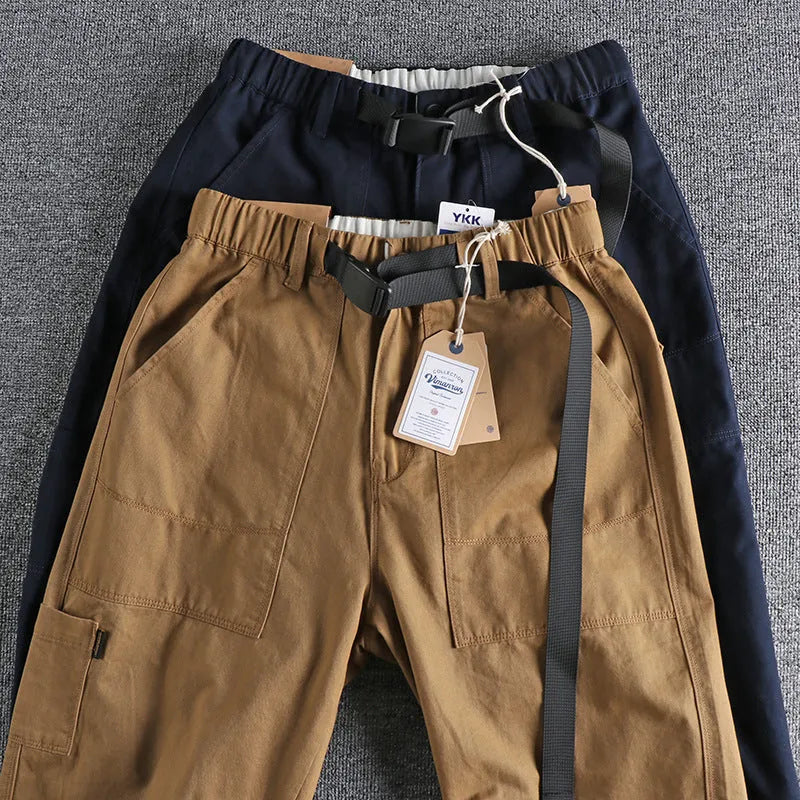 Men's khaki cotton work trousers featuring a buckle belt closure and a three-dimensional cut.