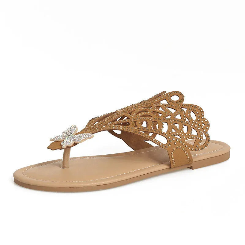 Women's black slip-on sandals with rhinestone decoration and flip-toe design on a white background.