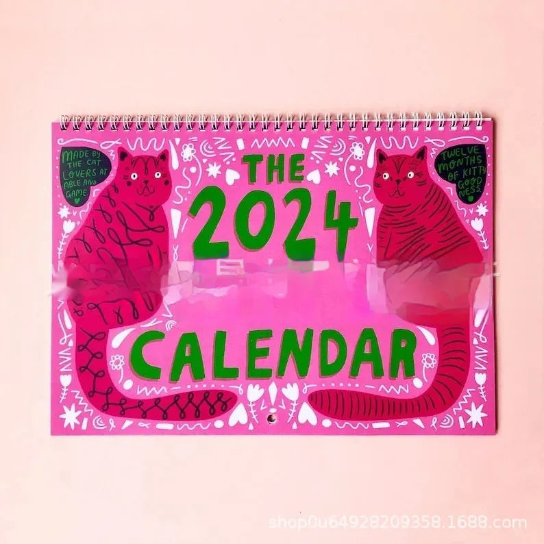 Cat-themed wall calendar with monthly date grid on paper for 2024 or 2025 planning