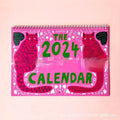 Cat-themed wall calendar with monthly date grid on paper for 2024 or 2025 planning