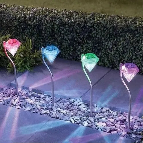 White solar-powered LED garden spotlight with adjustable head on a stake for outdoor use.