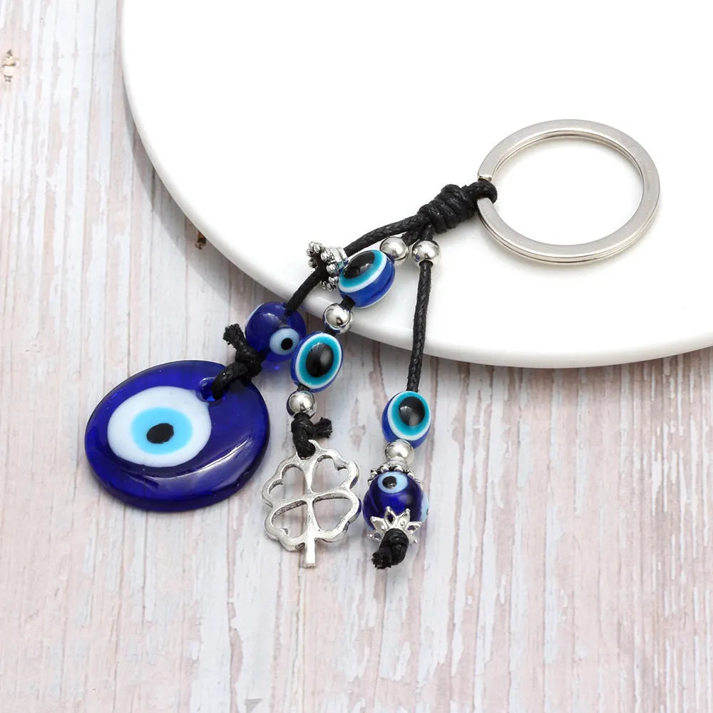 Blue evil eye keychain with metal plant-shaped pendant and unisex keyring design