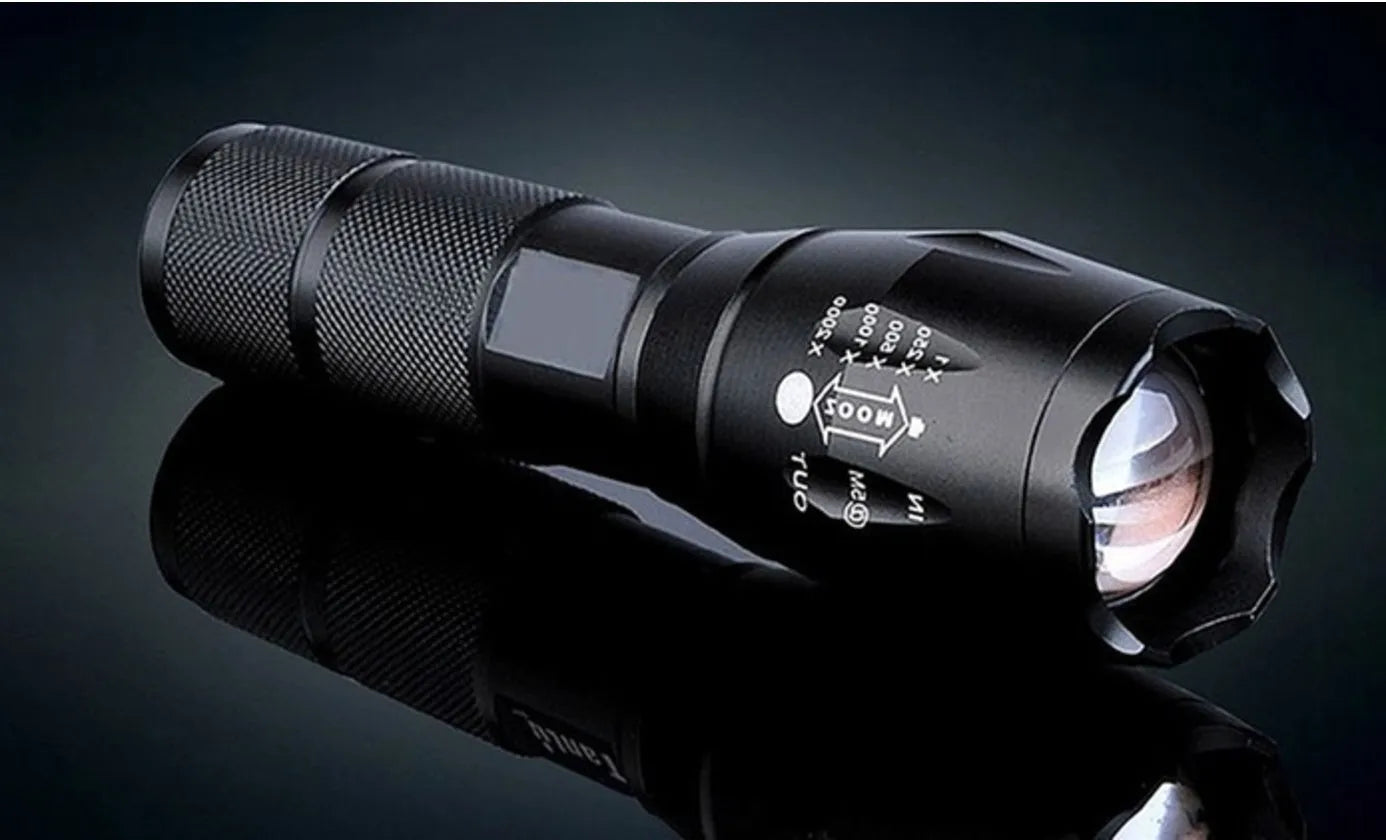 Black aluminium alloy zoomable LED flashlight with adjustable focus ring and textured grip.