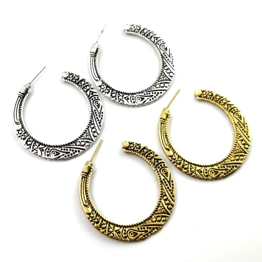 A pair of vintage-style C-shaped alloy earrings with an engraved surface, shown in bronze and silver colour options.