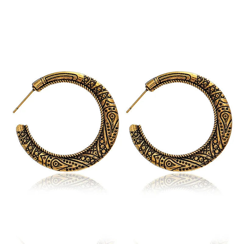 A pair of vintage-style C-shaped alloy earrings with an engraved surface, shown in bronze and silver colour options.