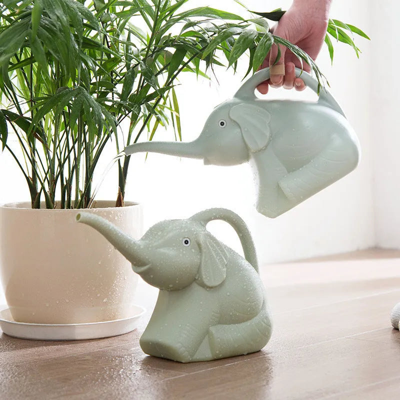 Pink children's watering can shaped like a sitting baby elephant with a long spout and bottle-shaped handle.