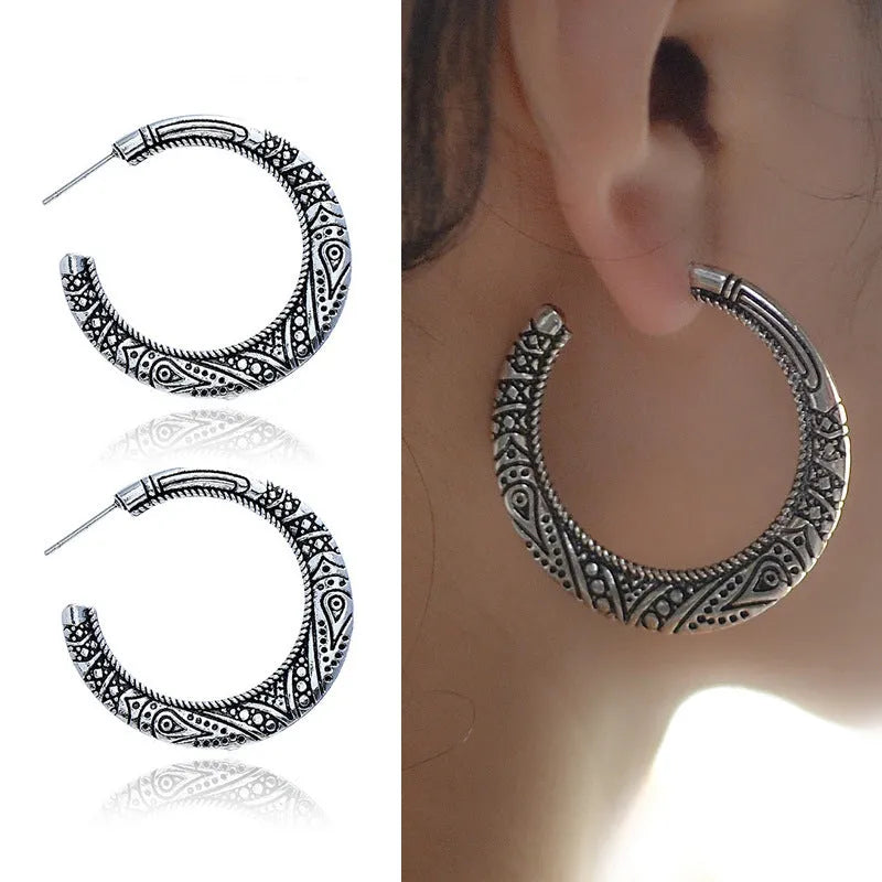 A pair of vintage-style C-shaped alloy earrings with an engraved surface, shown in bronze and silver colour options.