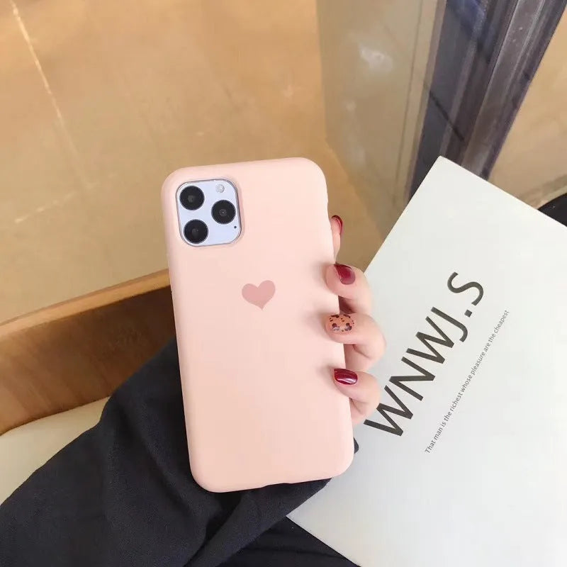Solid colour silicone phone case for iPhone, shown in dark green, on a table.