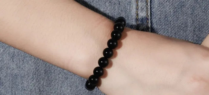 Black onyx bracelet with 8mm geometric agate beads on a black elastic cord.
