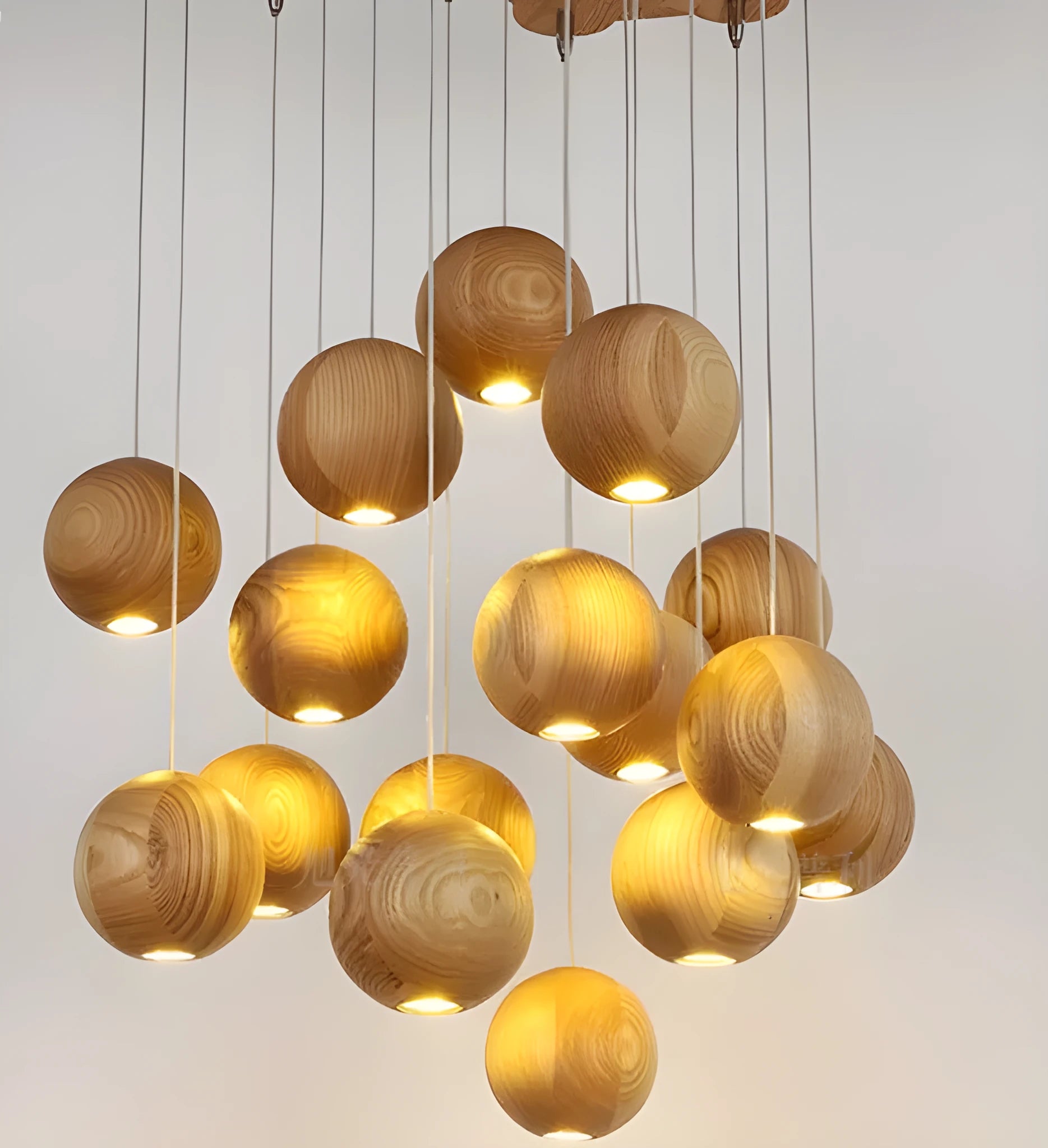 Nordic wood ball chandelier pendant light with adjustable cord, shown in a dining room setting.