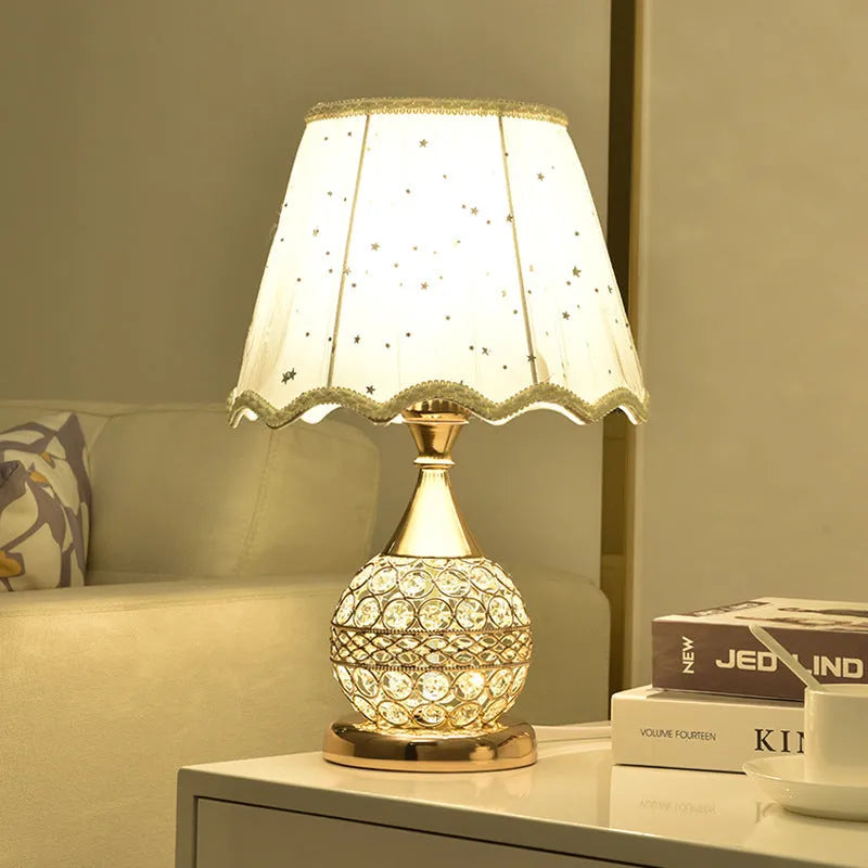 Gold crystal desk lamp with iron art base and remote control on a wooden table