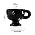 Hand-pinched irregular shaped solid colour ceramic mug on a table, showing its unique form and modern simplicity design.