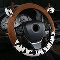 Short plush automotive steering wheel cover in black colour with protective handle design