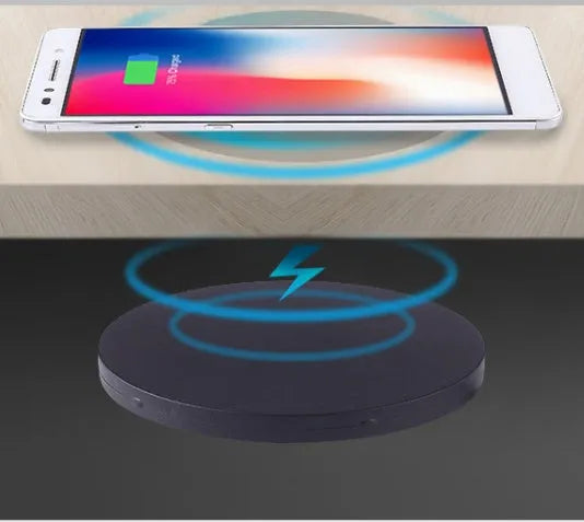 Black round 60mm diameter wireless phone charger for embedding into desk or table surface.