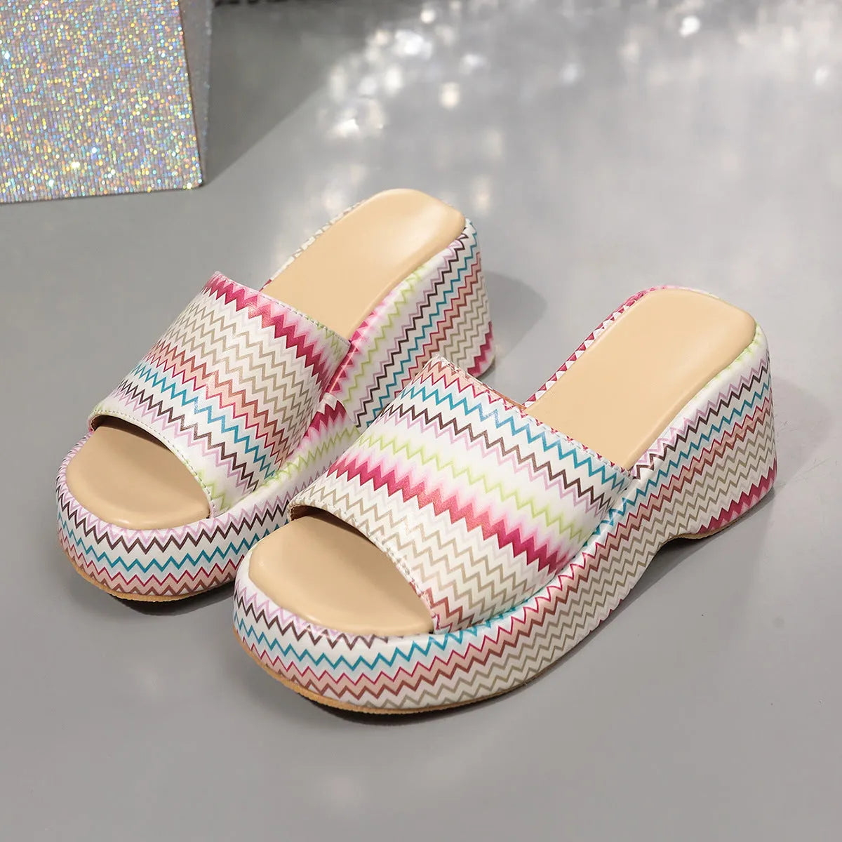 Colourful wave print wedge sandals for women on a beige background, showing fish mouth toe and thick sole.