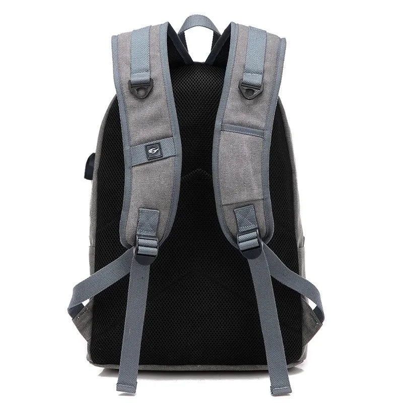 Canvas backpack with USB charging port shown in grey, featuring a laptop sleeve and front zipper pocket.