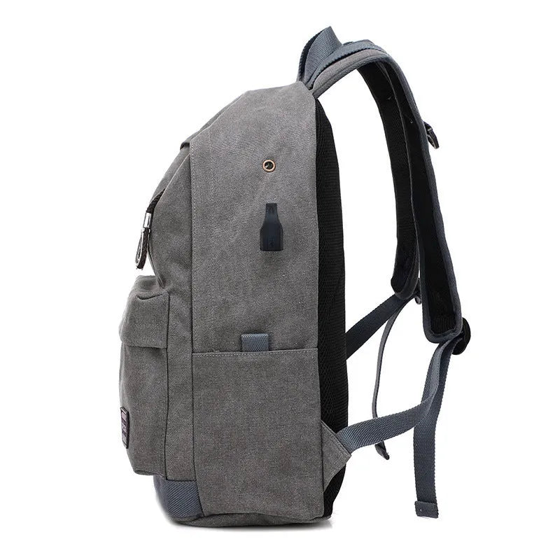 Canvas backpack with USB charging port shown in grey, featuring a laptop sleeve and front zipper pocket.