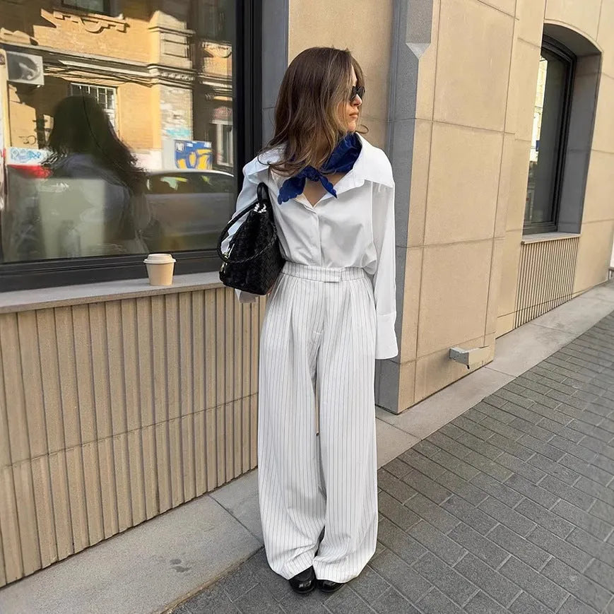 White striped wide-leg women's trousers with a front zip closure on a model