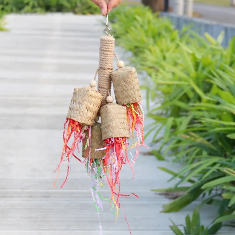 Colourful shredded paper parrot toy on wooden perch with sisal rope attachments