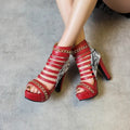 Women's black snakeskin high-top shoes with fish mouth front and thick Roman block heel on a white background.
