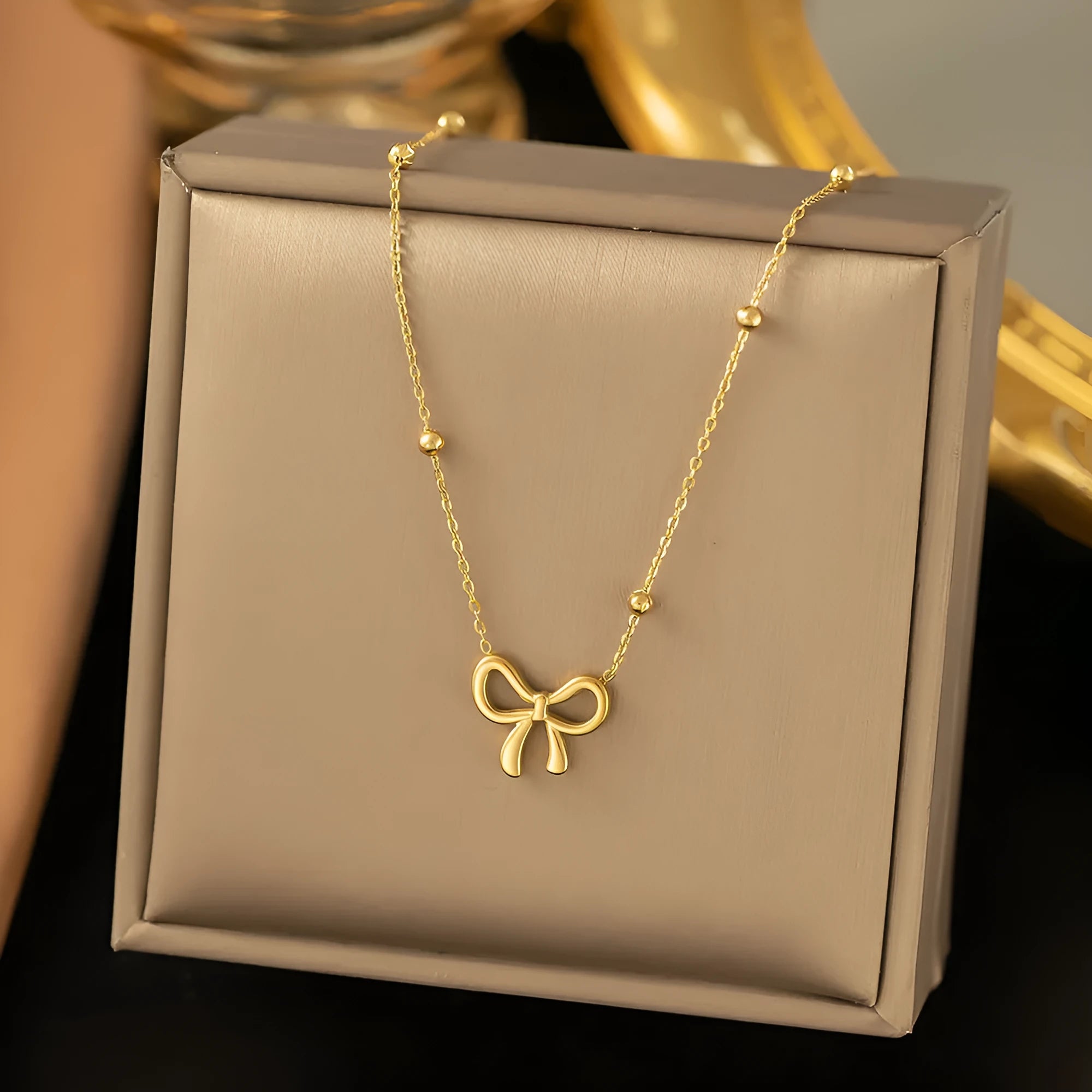 Gold electroplated bow necklace with adjustable cross chain for women