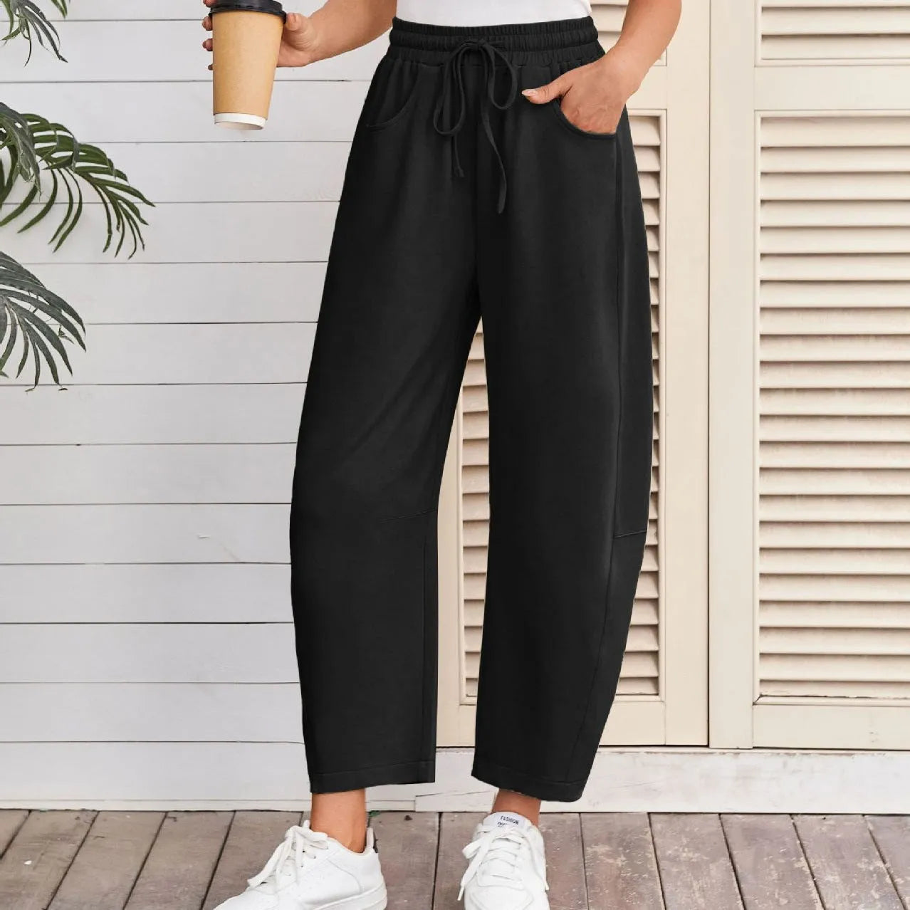 Loose cropped sweatpants with drawstring waist in apricot colour showing side pockets and street fashion styling