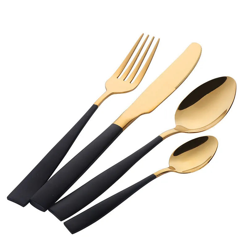 Black stainless steel four-piece cutlery set with mirror-polished finish on a plain surface