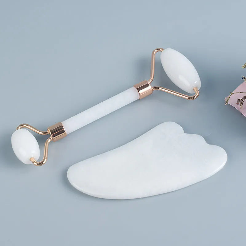 Natural white jade facial roller and gua sha scraping board set on a white background.
