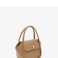 Women's winged leather handbag with cross-body strap in blue, showing latch closure and buckle detail.