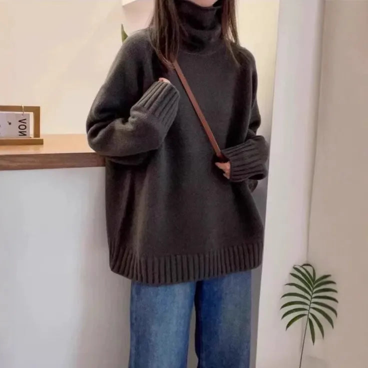 Red women's loose fit turtleneck sweater with a thick knit and curly pile collar on a hanger.