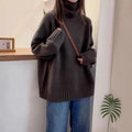 Red women's loose fit turtleneck sweater with a thick knit and curly pile collar on a hanger.