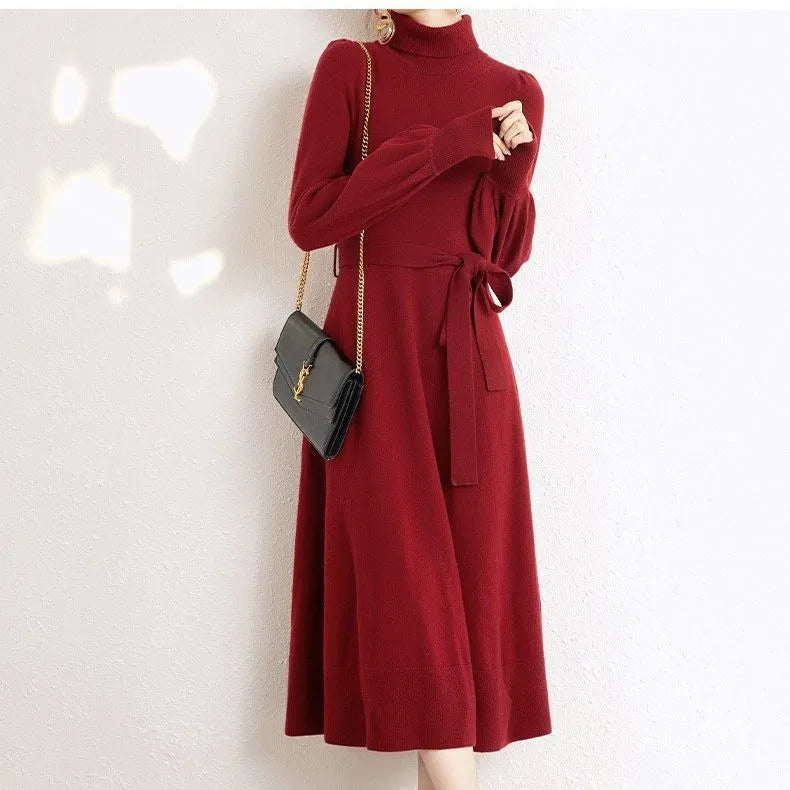 Turtleneck knitwear dress with elastic waist and loose mid-length skirt in solid colour.