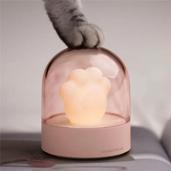 Grey and pink cat paw shaped night light with USB charging cable and musical rotation feature