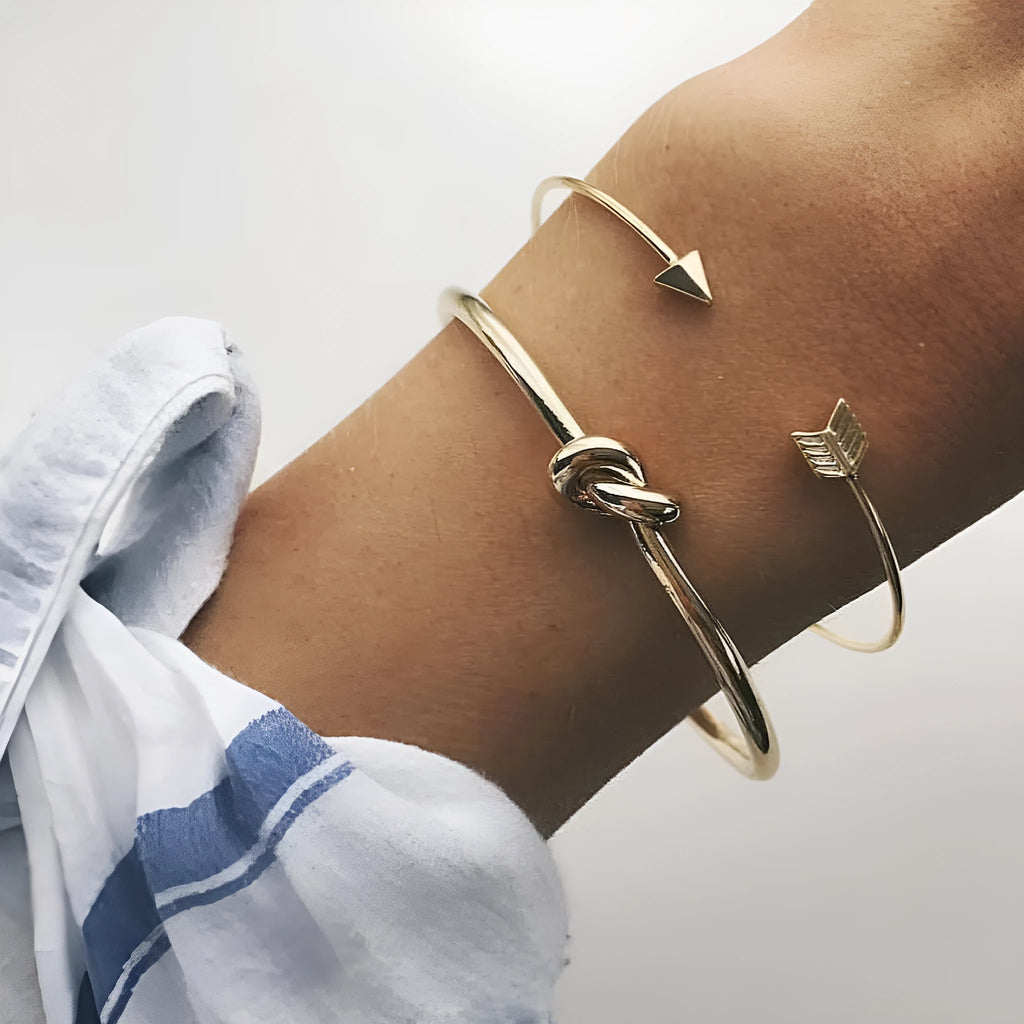 Gold women's cuff bracelet with arrow knot design on alloy electroplated band