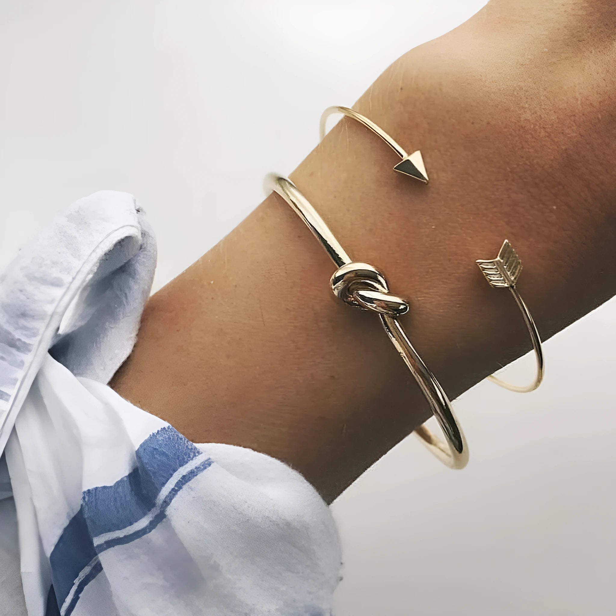 Gold women's cuff bracelet with arrow knot design on alloy electroplated band