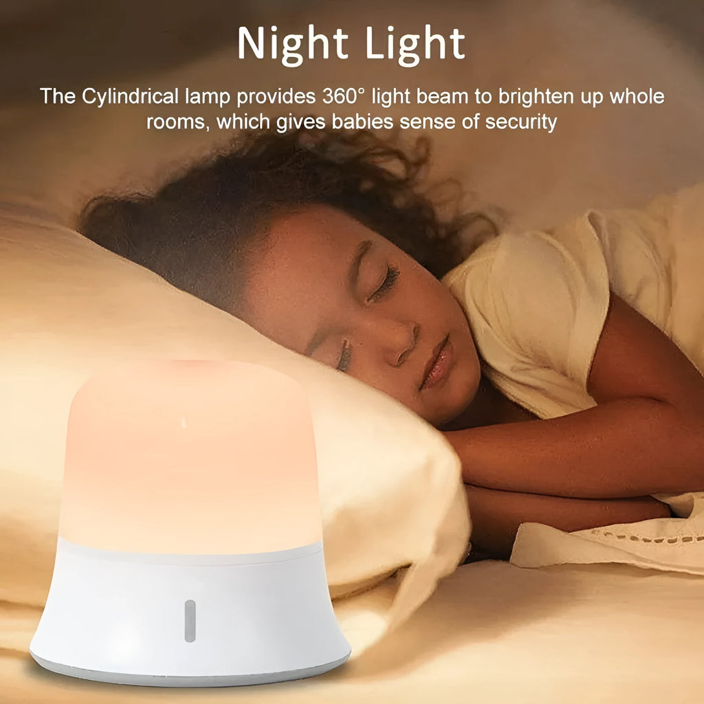 White rechargeable bedside night light with touch controls on a wooden table.