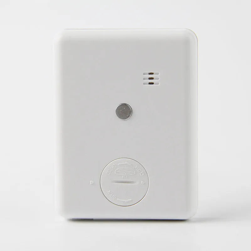 Black and white digital kitchen timer with magnetic back mounted on refrigerator