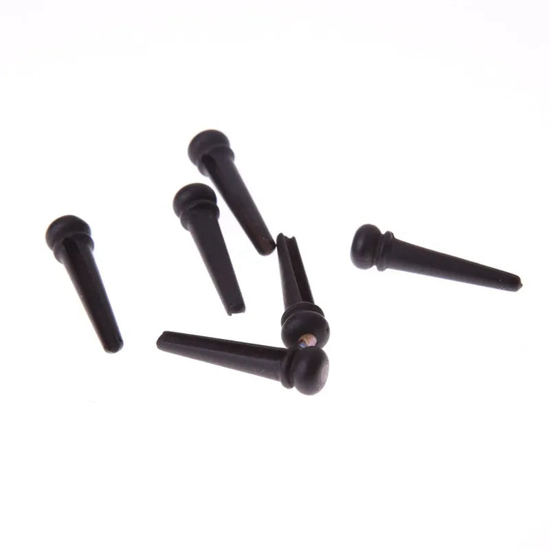 Six ebony guitar string nails with matt black finish and 5.3mm bayonet diameter
