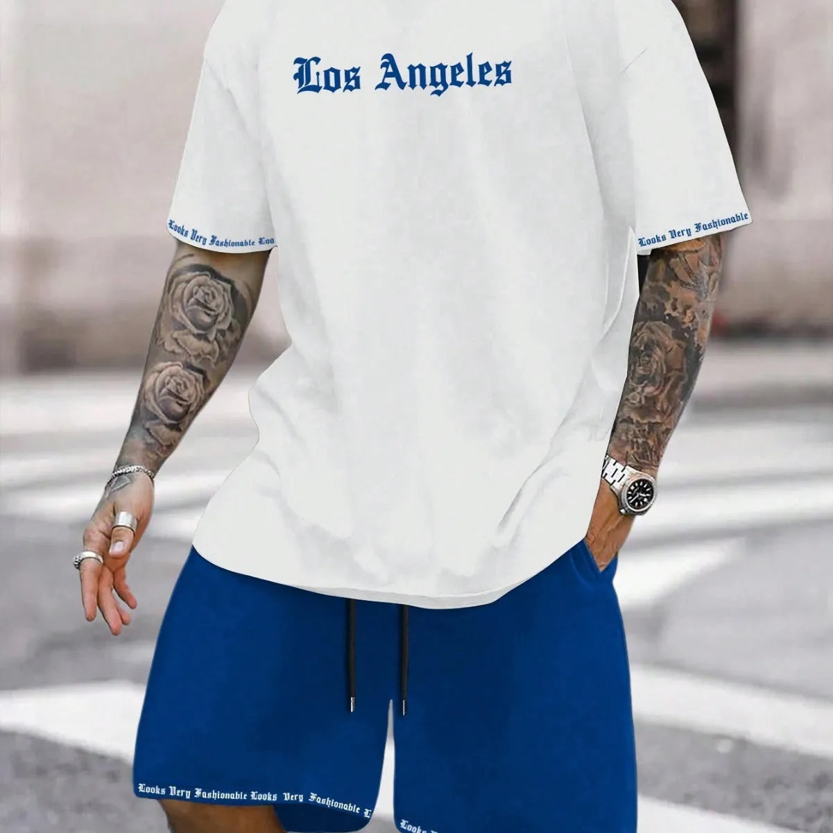 Man wearing a grey short sleeve athletic top and matching shorts from a polyester sportswear set.