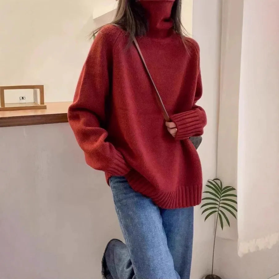 Red women's loose fit turtleneck sweater with a thick knit and curly pile collar on a hanger.