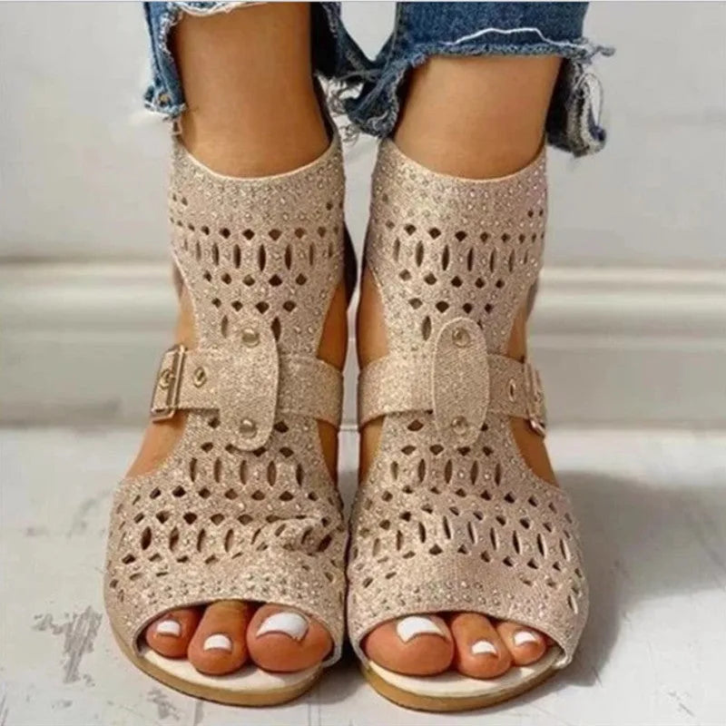 Women's beige flat sandals with a back zipper and low wedge heel.