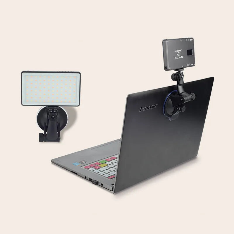 Black aluminium LED video conference light showing its slim profile and LED array, placed next to a laptop.