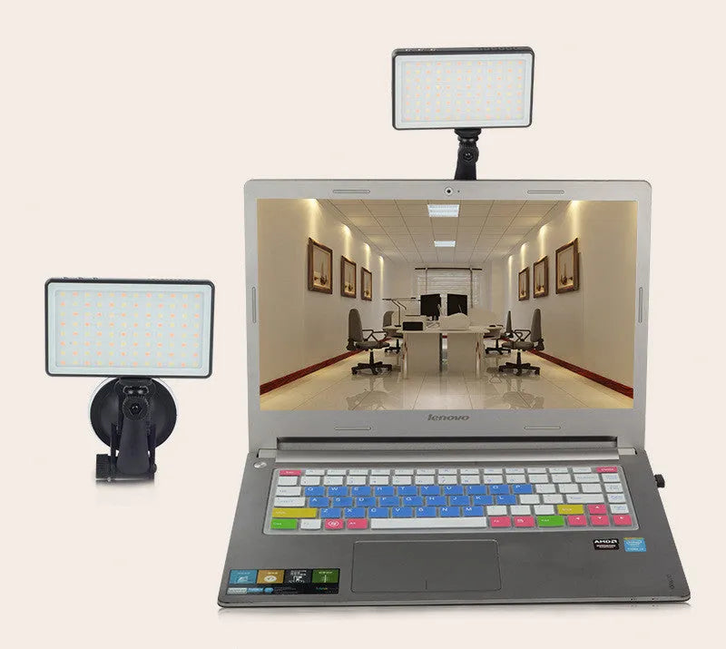 Black aluminium LED video conference light showing its slim profile and LED array, placed next to a laptop.