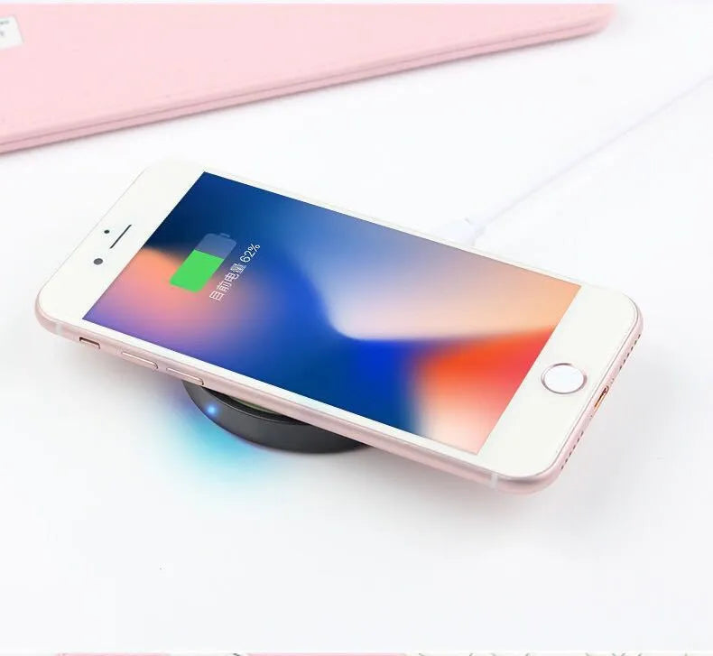 Square Qi wireless charging pad for mobile phones in six colour options on a wooden surface.