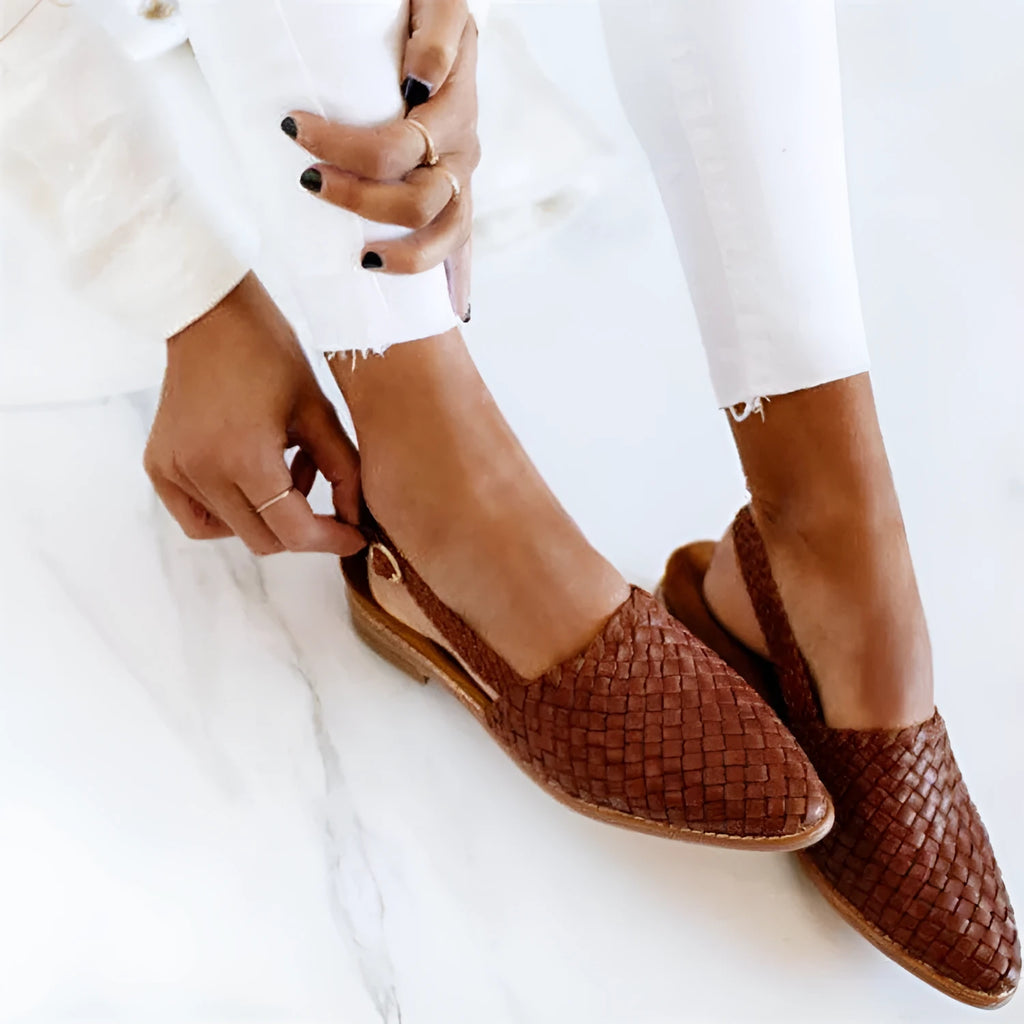 Women's flat buckle sandals with a pointed toe in blue, showing the microfiber upper and rubber sole.