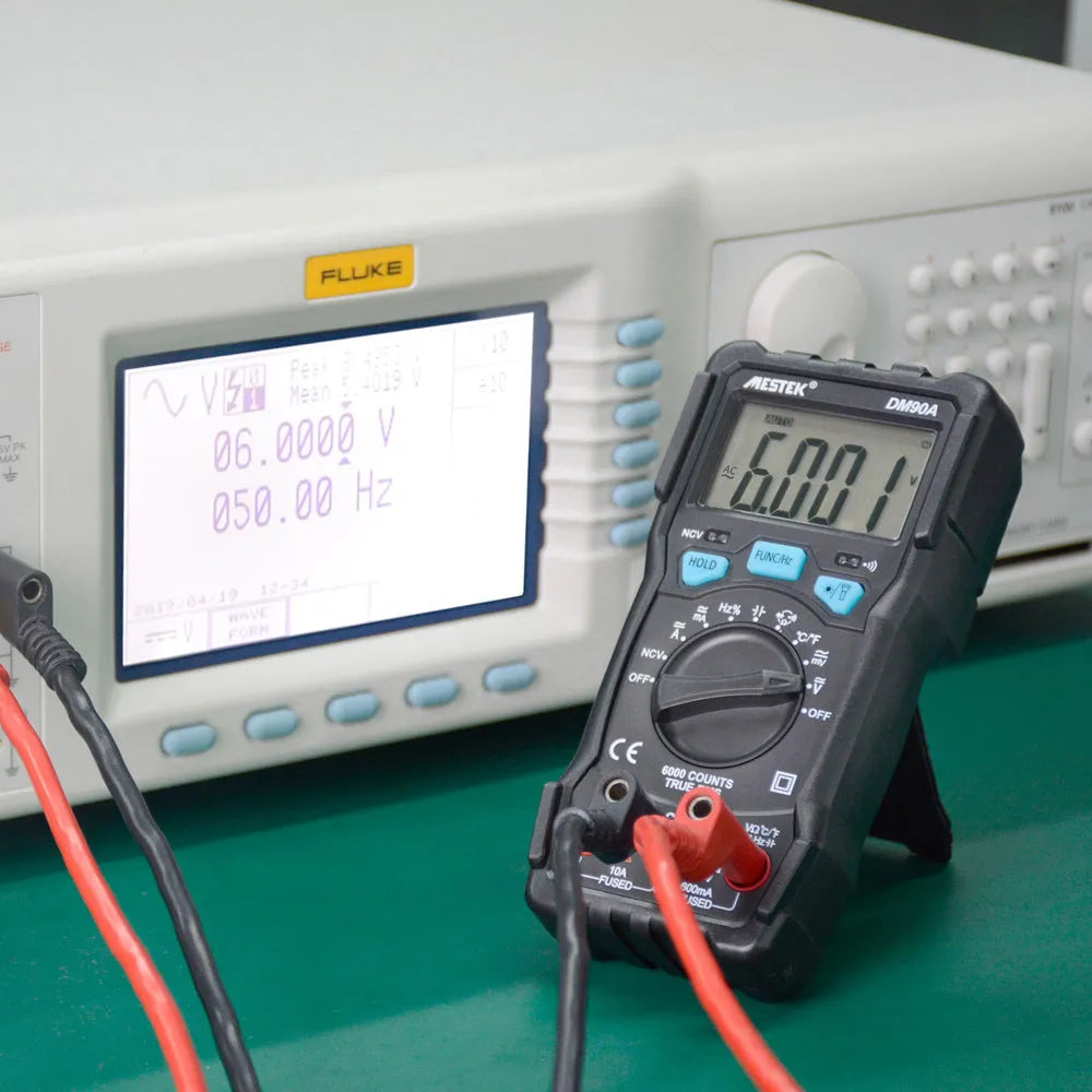DM90A digital multimeter with test leads showing 6000-count display and temperature measurement function