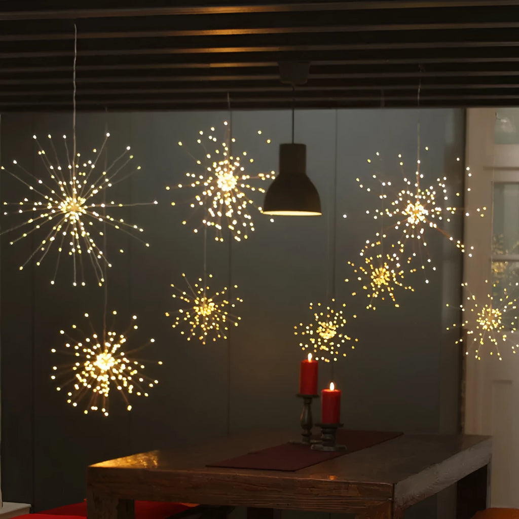 Solar-powered LED meteor shower light with multiple strands creating a warm white firework effect outdoors.