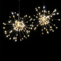 Solar-powered LED meteor shower light with multiple strands creating a warm white firework effect outdoors.