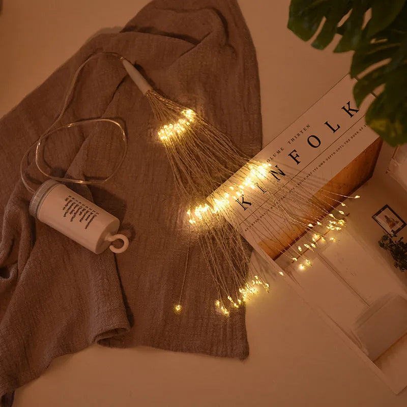 Solar-powered LED meteor shower light with multiple strands creating a warm white firework effect outdoors.